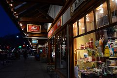 27B There Are Many Shops Along Banff Avenue With The Lights On After Sunset In Winter